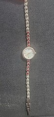 Allude Watch Women Gold Tone Mother of Pearl Dial Red Rhinestone Band Runs 7.25″